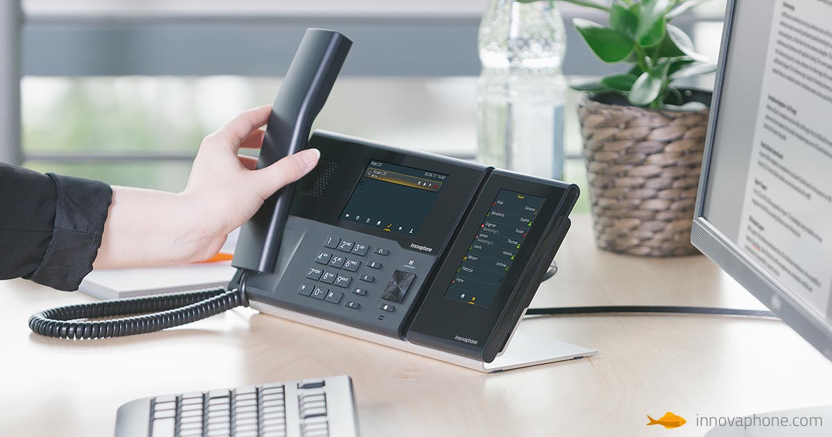Eine Hand die einen Hörer von einem Telefon hebt